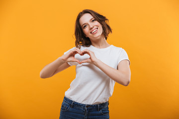 Wall Mural - Happy young woman looking aside make heart gesture.