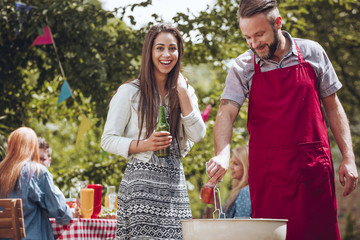 Wall Mural - Cheerful couple standing by grill