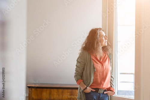 Fotografie, Obraz Attractive middle-aged woman standing with her hands in her pockets of her jeans