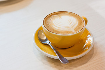 Wall Mural - Cappuccino in a cup on a wooden table in a coffee shop