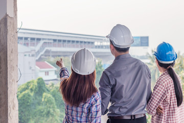 Wall Mural - Group of engineer checking the blueprint and talking about construction project with commitment to success at construction site