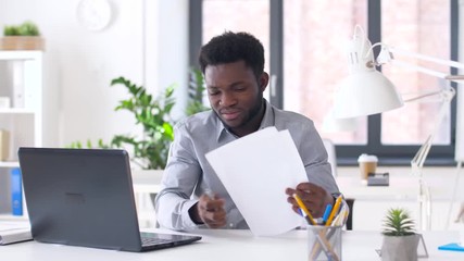 Sticker - business, people, paperwork and technology concept - african american businessman with laptop computer and papers working at office