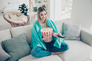 Poster - Top view portrait of pretty, charming nice cheerful cute girt searching for interesting program on tv, having remote controller on hand and bucket of pop corn, sitting in livingroom