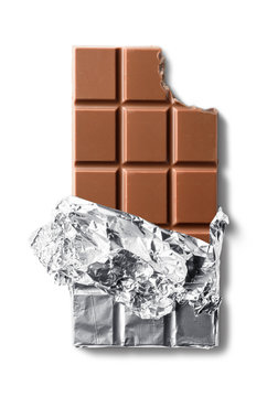 Top view of bitten milk chocolate bar in foil. Isolated on white background