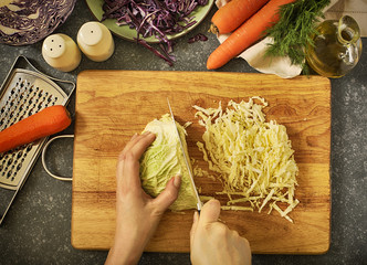 Canvas Print - Coleslow salad preparation. Women's hands cut vegetables for salad.