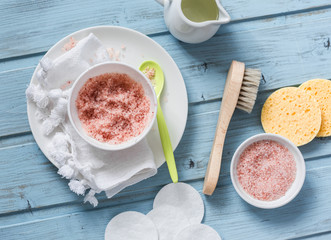Wall Mural - homemade pink himalayan salt and coconut oil body scrub on a blue background, top view. beauty, skin