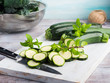 Cutting fresh zucchini on wooden board. Cooking vegetables