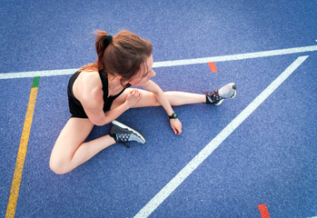 Sticker - Top view of athletic woman sitting on running track and resting after training