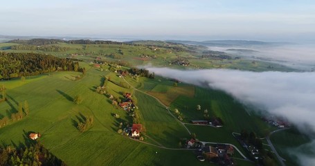 Wall Mural - Aerial Footage of the hilly landscape in central Switzerland on a beautiful spring morning with some morning fog
