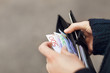 © Johnér - Woman holding open wallet with banknotes