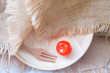 One red cherry on wooden dish