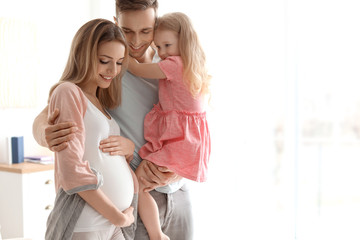 Canvas Print - Young pregnant woman with her family at home