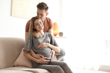 Wall Mural - Young pregnant woman with her husband at home