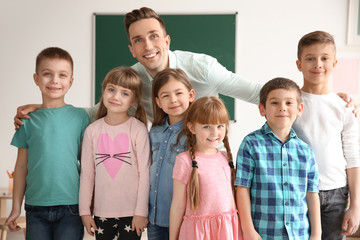 Sticker - Cute little children with teacher in classroom at school