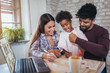 © Mediteraneo - Mom and dad drawing with their daughter. Girl and mixed race parents having fun at home.