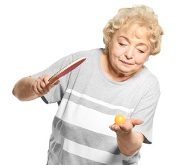 Wall Mural - Senior woman playing table tennis against white background