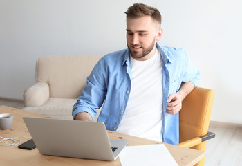 Wall Mural - Young man working with laptop at desk. Home office