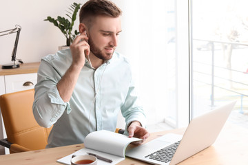 Wall Mural - Young man working with laptop at desk. Home office