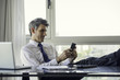© PhotoAlto - Man using smart phone in office