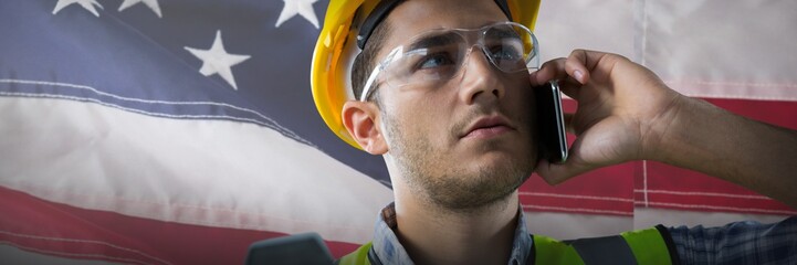 Wall Mural - Composite image of serious construction worker on the phone