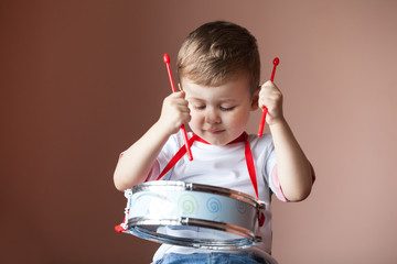 Little boy playing the drum. Child development concept.