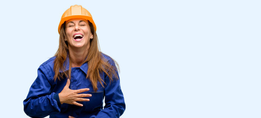 Engineer construction worker woman confident and happy with a big natural smile laughing isolated blue background