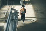 Fototapeta Przeznaczenie - Young woman running alone up stairs