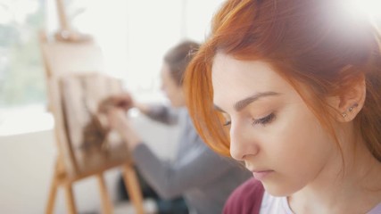 Wall Mural - Young female woman in front of artist draws sketches of woman figure