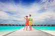 © el.rudakova - happy young couple walking on wooden bridge by the beach. Maldives