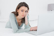 © WavebreakmediaMicro - Casual sad young woman using laptop in bed