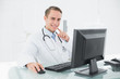 © WavebreakmediaMicro - Smiling male doctor with computer at medical office