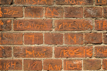Brick Wall With Names Carved Into It 