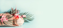 Summer Holiday  . Beach Accessories : Straw Hat With Palm Leaves And Flowers, Pink Sun Glasses And Coconut Cocktail On Blue Turquoise Background, Front View. Tropical Vacation Travel Concept. Banner