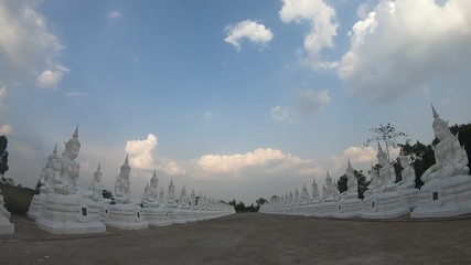 Wall Mural - row buddha statue with blue sky and cloud background,time lapse