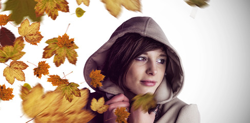 Poster - Beautiful woman wearing winter coat looking away against autumn leaves