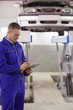 © WavebreakmediaMicro - Concentrated mechanic holding a clipboard
