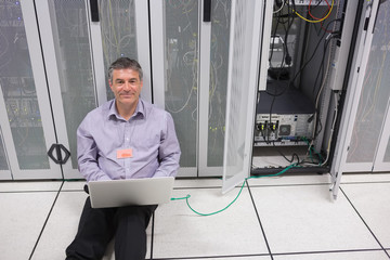 Aufkleber - Smiling man doing server maintenance with laptop
