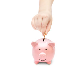 Wall Mural - Child hand putting coin into money box.