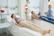 Two transfused patients lying on a medical bed