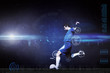 Football player kicking ball against blue dots on black background