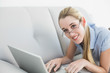 © WavebreakmediaMicro - Content calm businesswoman working on her laptop lying on couch
