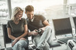 © Yakobchuk Olena - Portrait of happy young male and beaming lady looking photos on camera. Satisfied lovers with appliance concept