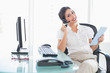© WavebreakmediaMicro - Cheerful call centre agent using her digital tablet on a call