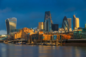 Wall Mural - London, England - Beautiful dramatic sky and golden hour sunlight at Bank District of London with famous skyscrapers