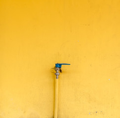 Faucet for water on the yellow wall