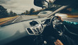 © Duncan Andison - A female driver driving a car along a busy road on an English single carriageway on a cloudy overcaste day. Filter and styling applied.
