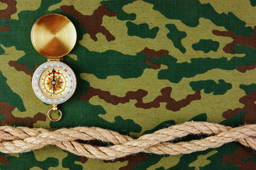 Wall Mural - Compass and rope on a camouflage background