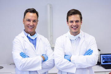 Portrait of happy dentists standing with arms crossed