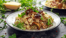 Italian Mushroom Risotto With Parmesan Cheese And Wild Rocket On Top.