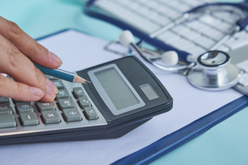 medical cost closeup calculates on an electronic calculator